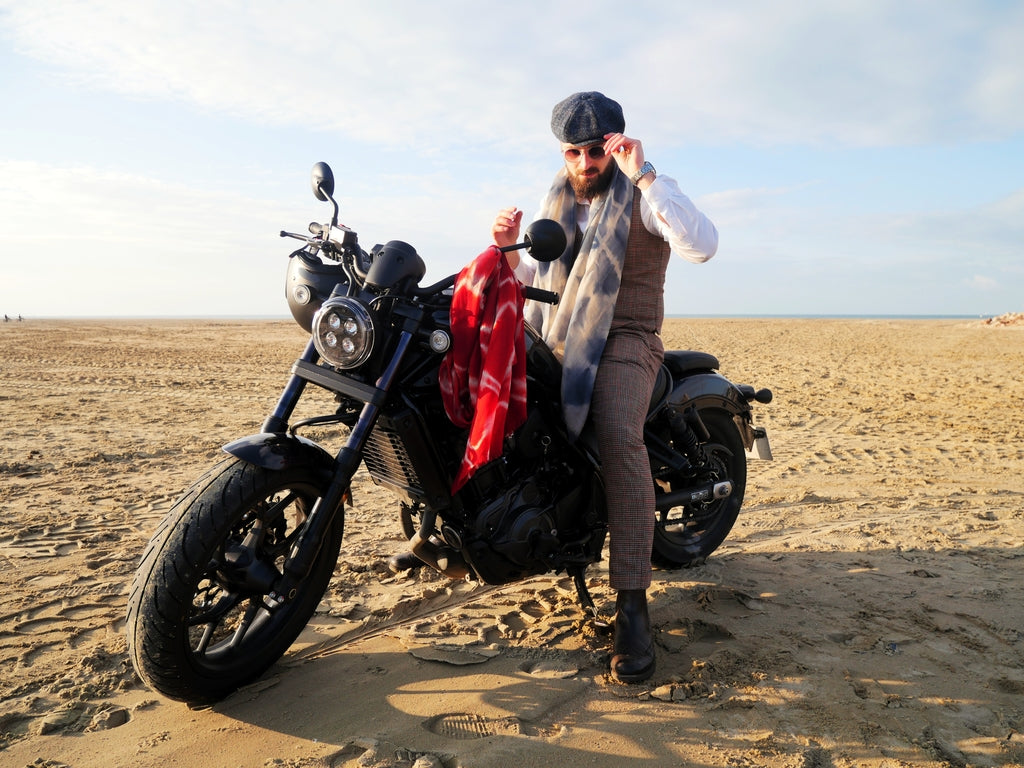 Jules Rouby sur sa moto sur la plage de Deauville avec une écharpe au tour du coup 